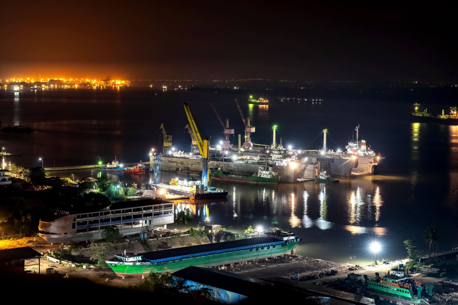 Ships in a dry dock at a shipbuilding and repair yard at night